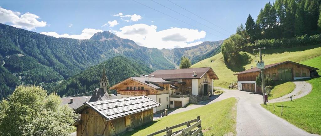 a village in the mountains with a road and buildings at Gasserhof in Campo di Trens