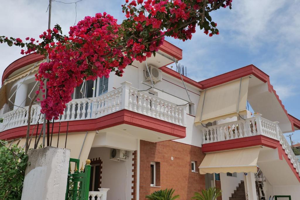 a house with red flowers on the balcony at Vila Melisa in Ksamil