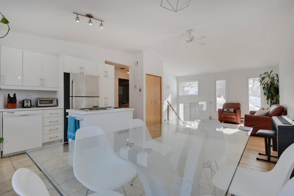 a kitchen and living room with a glass table and chairs at Cozy home with hot tub near airport in Quebec City