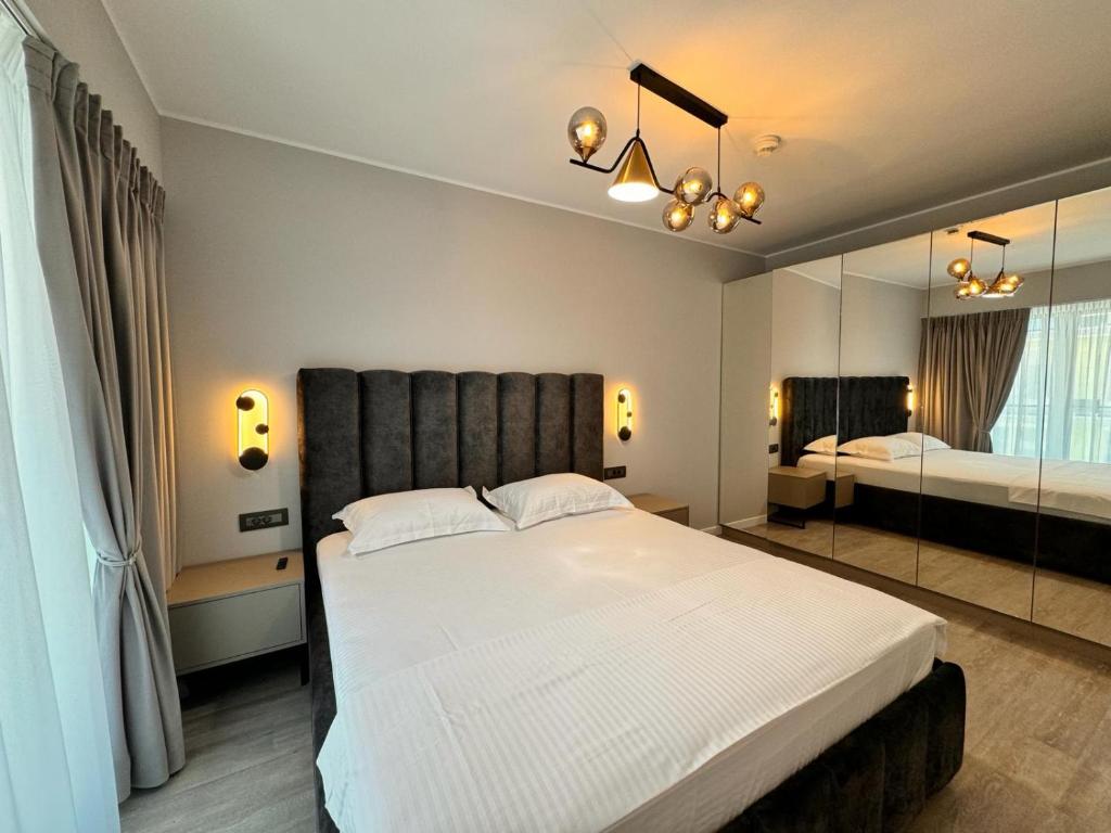 1 dormitorio con 1 cama blanca grande y espejo en Zora Bliss, en Năvodari