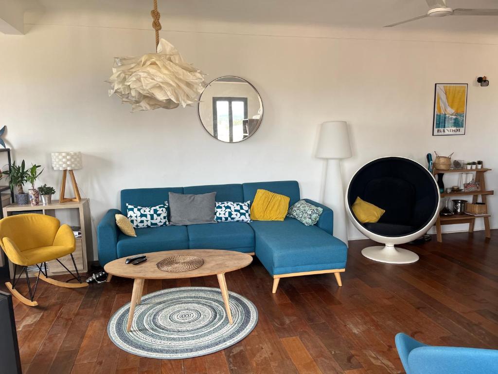 un salon avec un canapé bleu et une table dans l'établissement Loft 80m2 Bandol dernier étage à 100m plage, centre, port, à Bandol