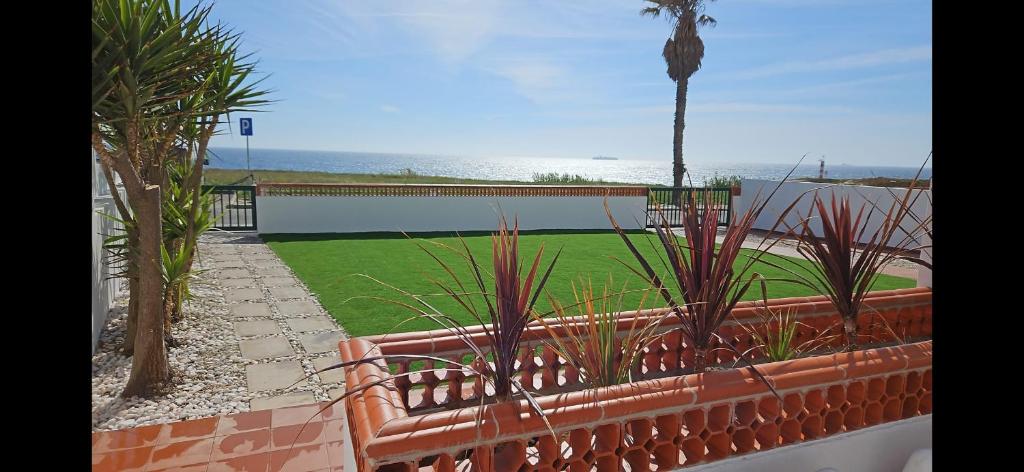 a balcony with a view of a yard with plants at Casa do Mar em Porto Covo in Porto Covo