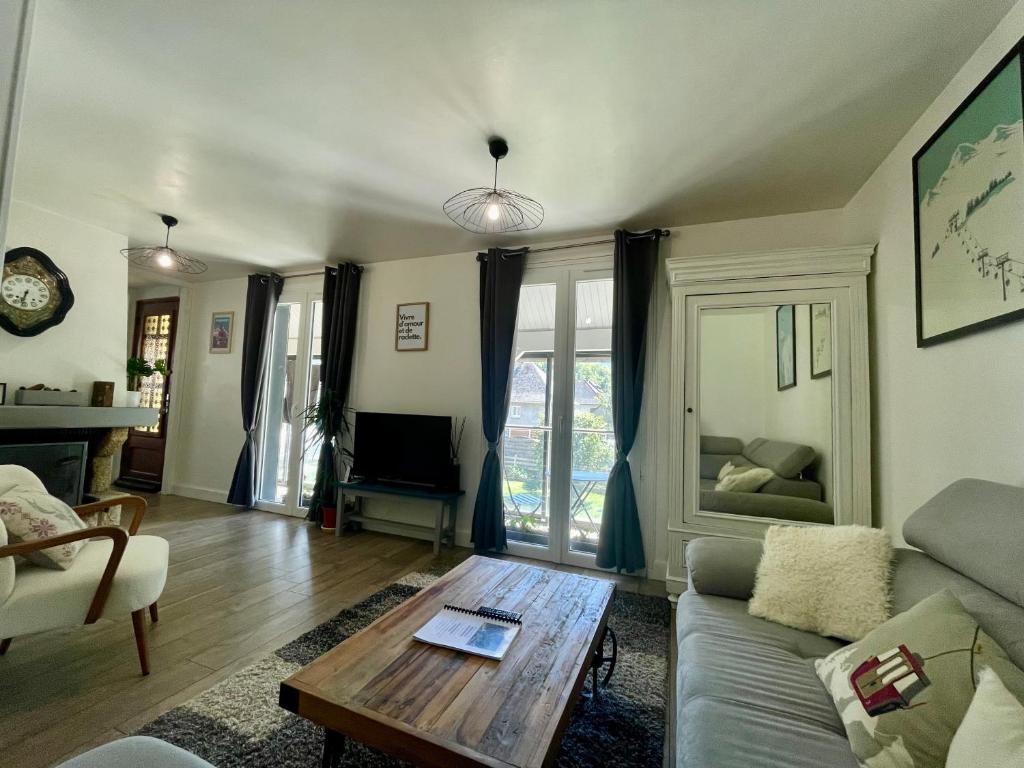 una sala de estar con un sofá y una mesa en Bel Appartement dans résidence cheminée /Jardin, en Luz-Saint-Sauveur