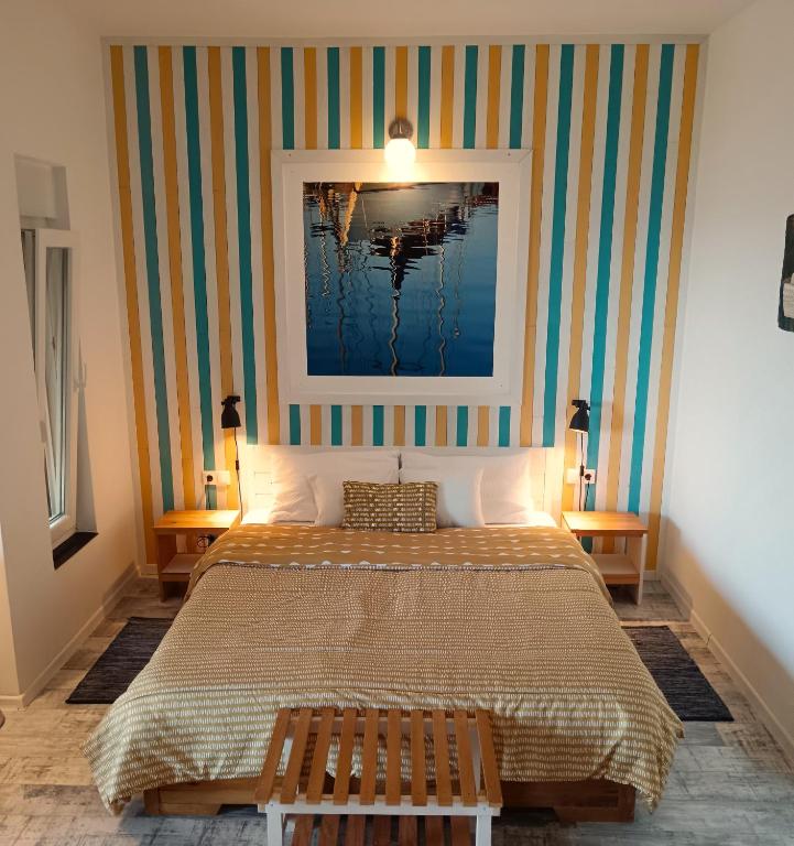 a bedroom with a bed and a painting on the wall at MaraMare Apartments in Stara Baška