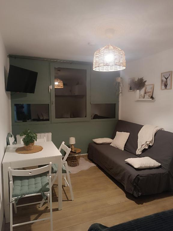 a living room with a bed and a table at Le petit Miraline in Villarembert