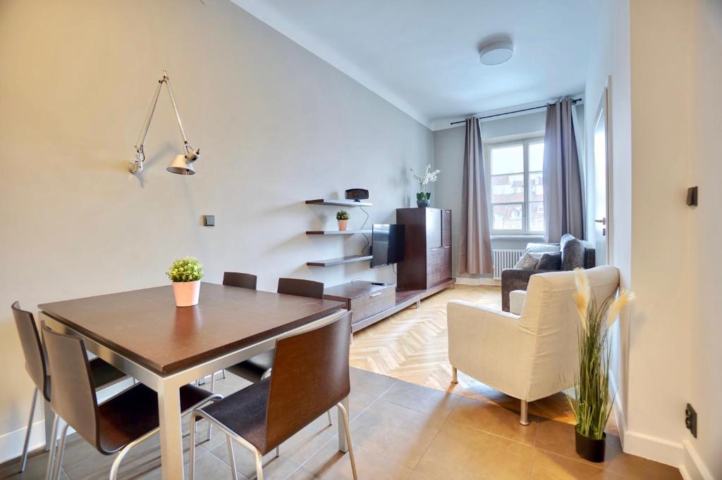 comedor y sala de estar con mesa y sillas en Warsaw Premium Apartments MARKET VIEW Old Town en Varsovia