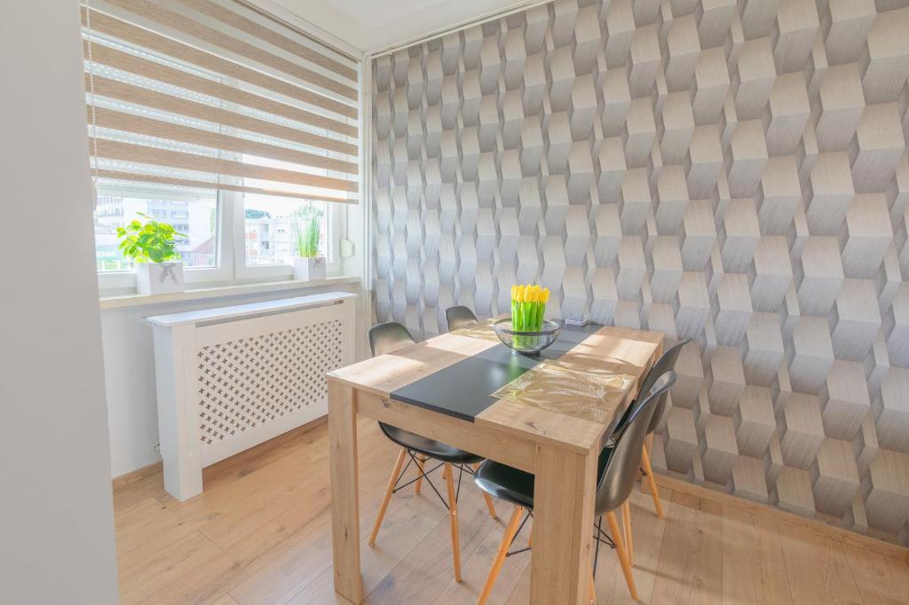 een eetkamer met een houten tafel en stoelen bij Apartman Lumi in Čakovec