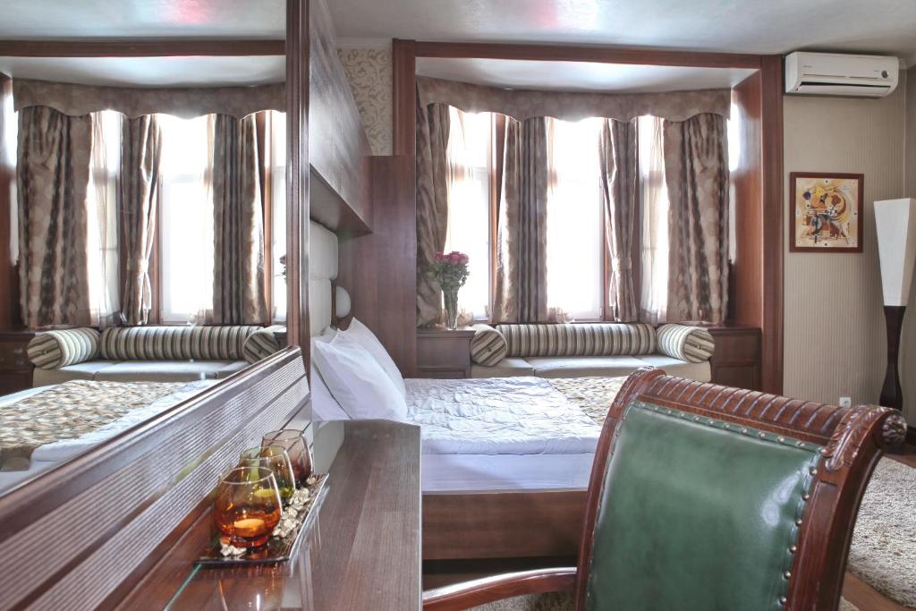 Zimmer mit einem Bett, einem Tisch und einem Spiegel in der Unterkunft Vila Terazije in Belgrad