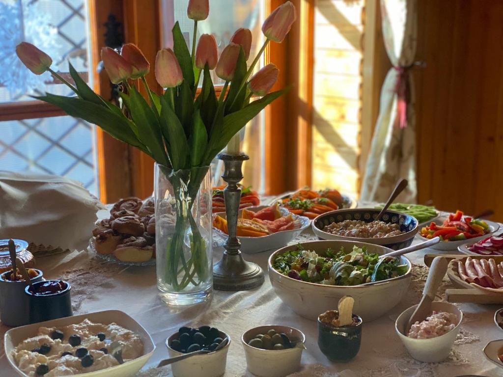 una mesa con tazones de comida y un jarrón de flores en Willa Alta, en Bukowina Tatrzańska