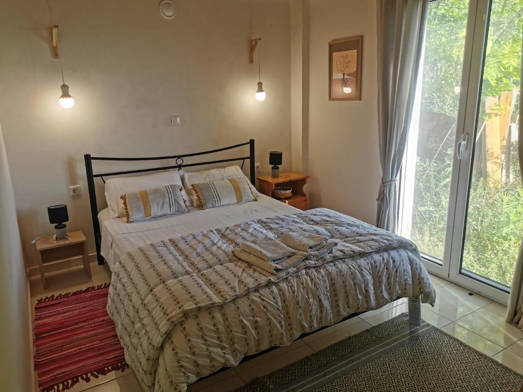 - une chambre avec un lit et une grande fenêtre dans l'établissement Peacefull Sea View Maisonette, à Petrití