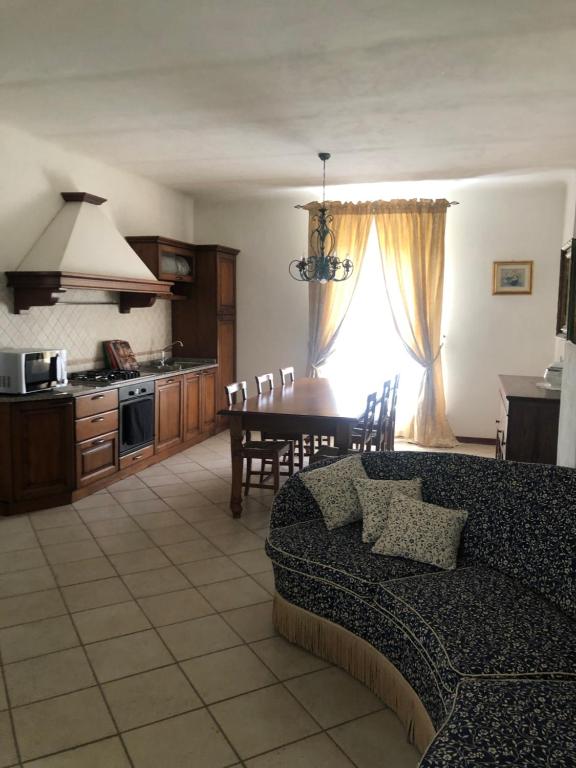Una sala de estar con un sofá y una cocina con una mesa. en Casa Simonetti, en Lucca