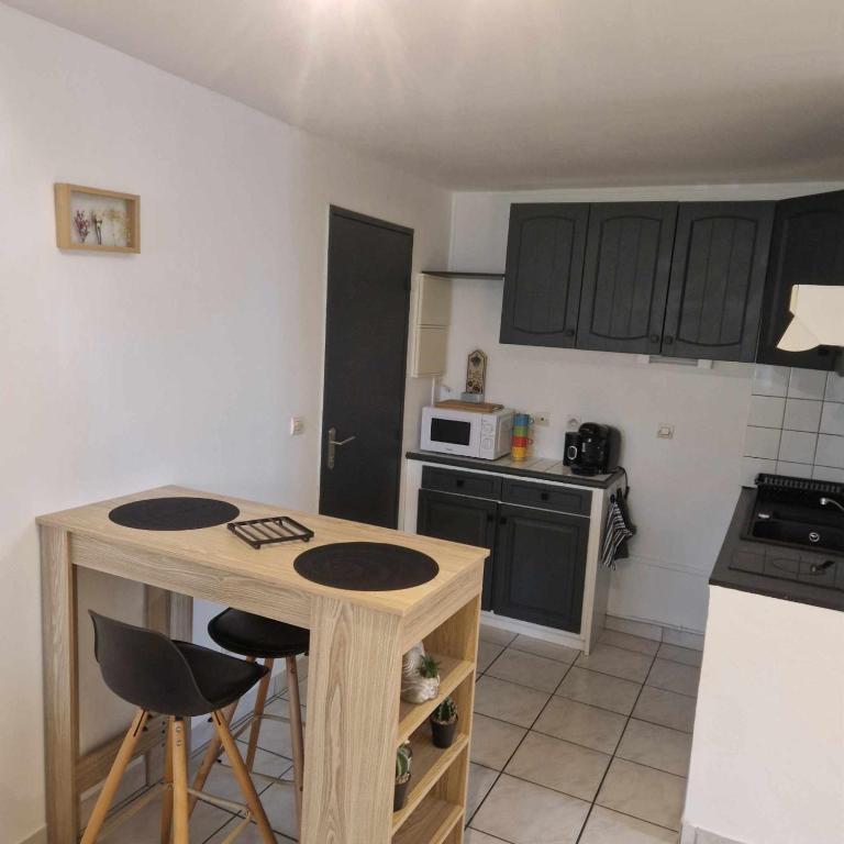 - une petite cuisine avec une table et un comptoir dans l'établissement Au bord de mer, à Sainte-Marie-la-Mer