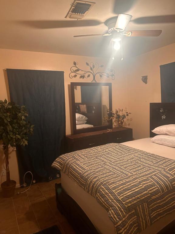 1 dormitorio con cama, espejo y ventilador de techo en Peachy sunset en Tallahassee