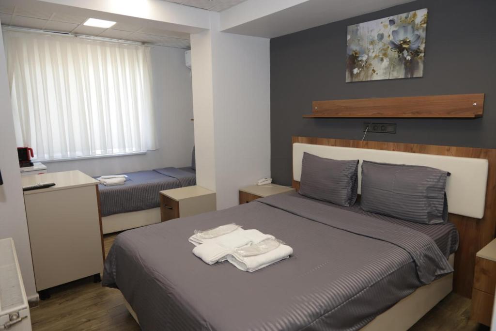 ein Schlafzimmer mit einem Bett mit zwei Handtüchern darauf in der Unterkunft GÜNDOĞDU OTEL in Lapseki