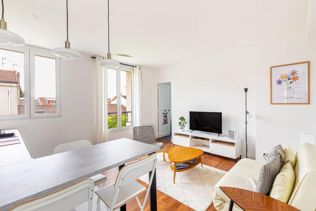a living room with a couch and a table at GuestReady - A minimalist comfort in Vanves in Vanves