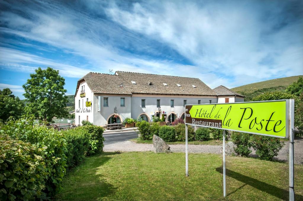 un panneau jaune devant une maison dans l'établissement Hôtel Restaurant de la Poste et La Grange Détente, espace bien-être, à Châteauneuf-de-Randon