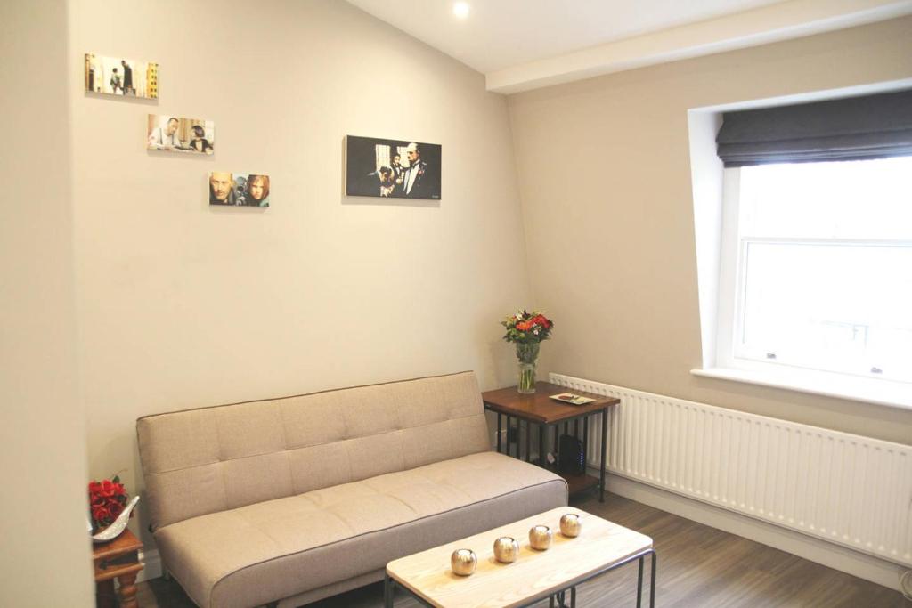 a living room with a couch and a table at GuestReady - Quaint English Flat near Portobello in London