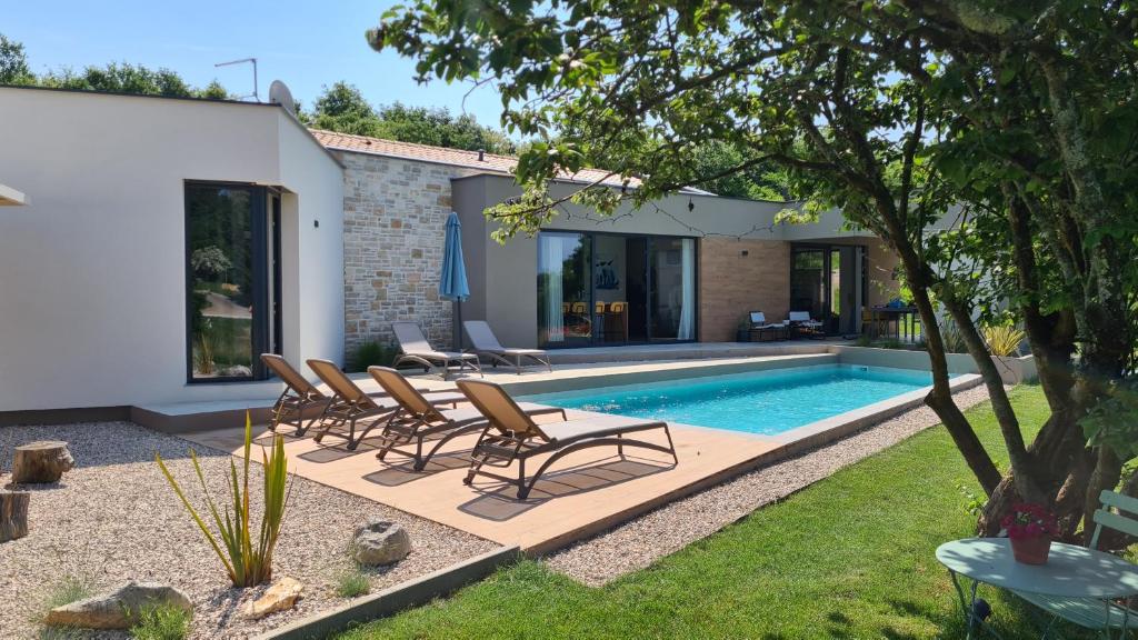 a swimming pool with chairs and a house at Villa ZEL in Pazin
