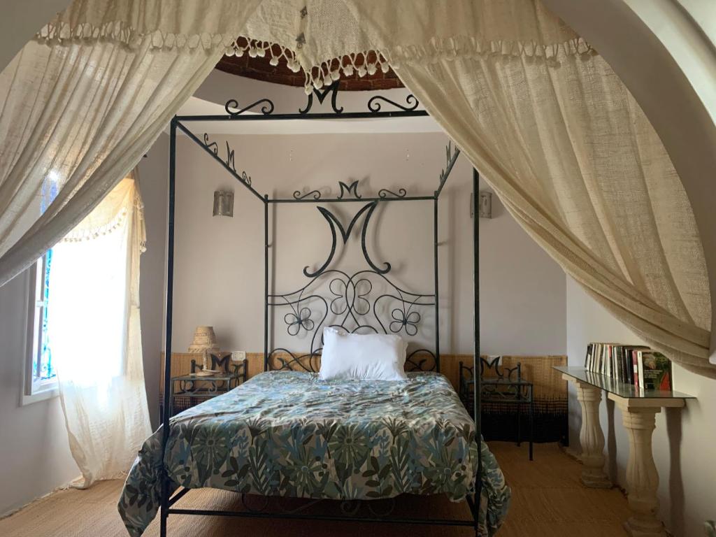 una camera da letto con un letto con baldacchino di metallo di Tamalou Djerba a Midoun