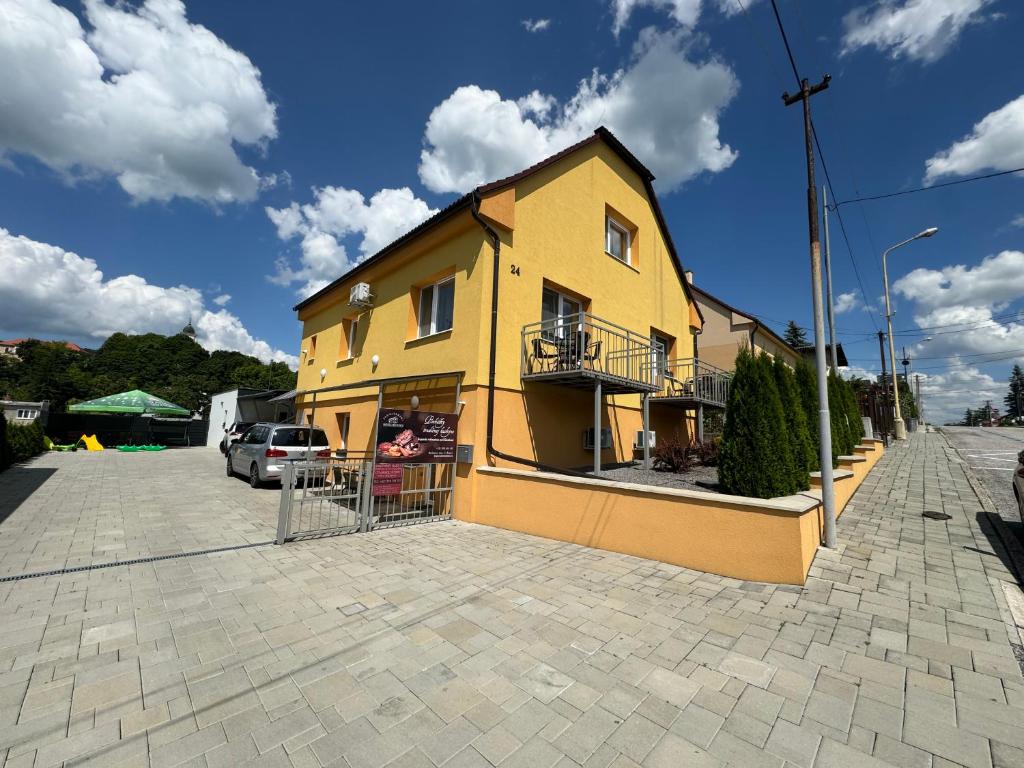 a yellow building on a street with a parking lot at Apartmány Hujer 2 in Bojnice