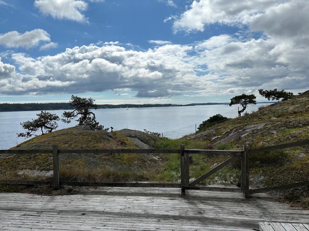 een houten bank op een promenade naast een waterlichaam bij Seaside Bliss for Families: Home Away from Home in Stavsnäs