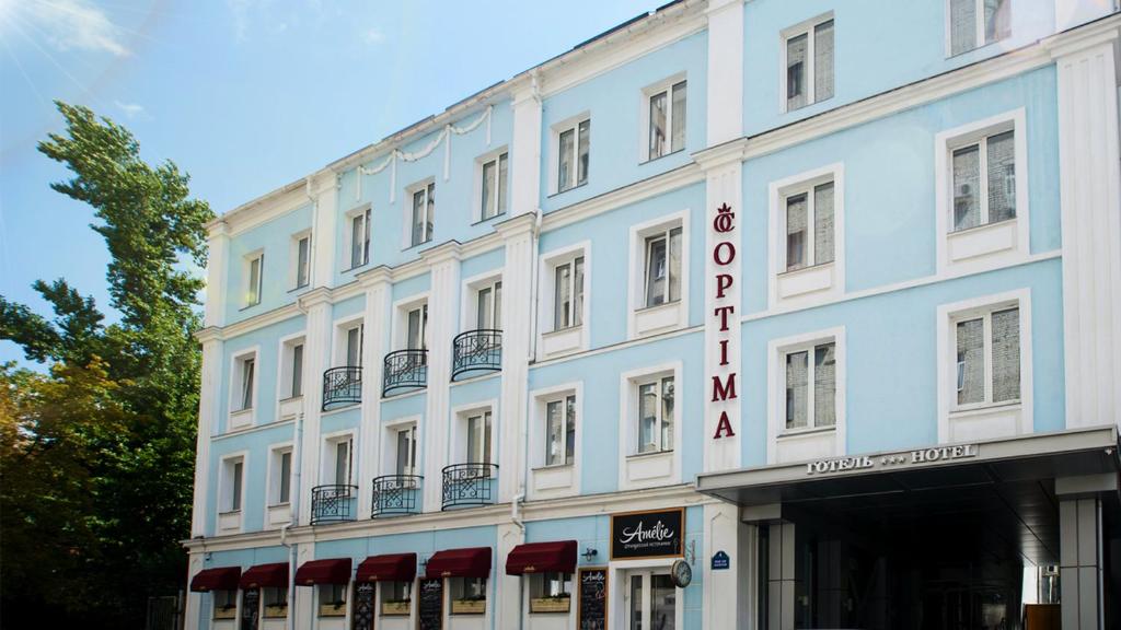 un gran edificio blanco con un cartel. en Optima Collection Kharkiv Hotel, en Járkov