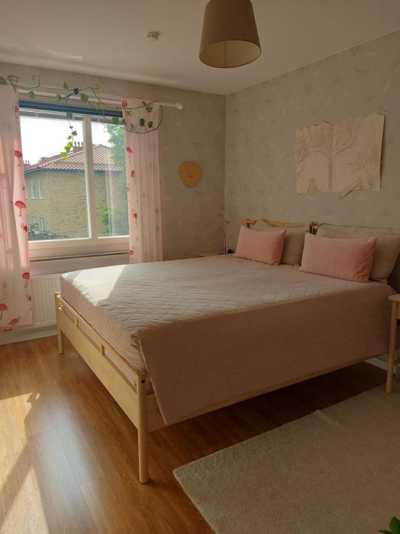 a bedroom with a large bed with pink pillows at feel like your own home in Linköping