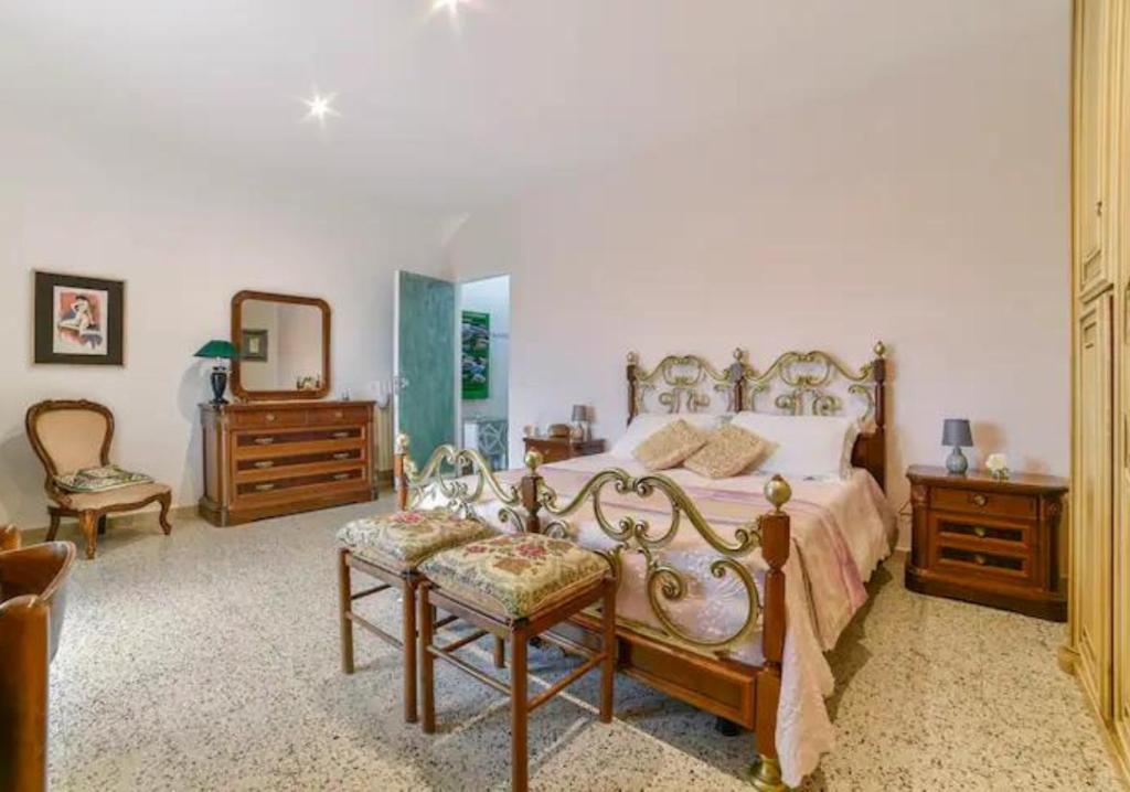 una camera con un letto, due sedie e uno specchio di Casa indipendente e con parcheggio a Tricarico, vicino Matera a Tricarico
