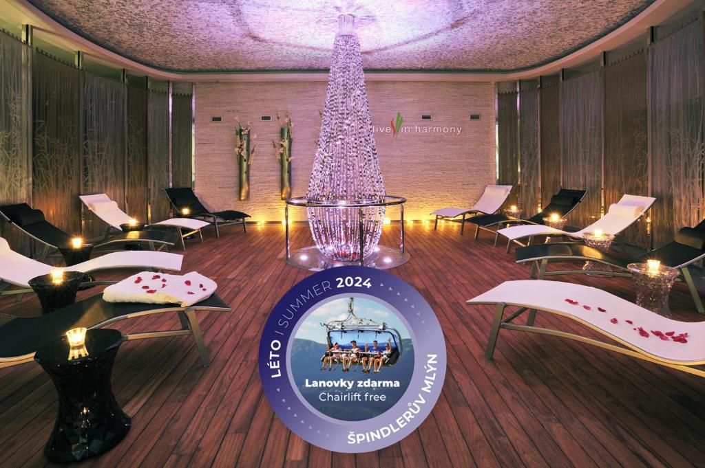 Harmony Club Hotel في سبيندلروف ملين: شجرة عيد الميلاد في غرفة بها كراسي وعلامة