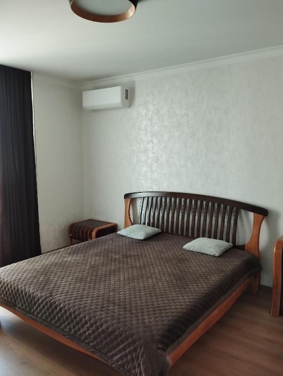um quarto com uma cama com um edredão castanho em VIP квартира однокімнатна em Lutsʼk