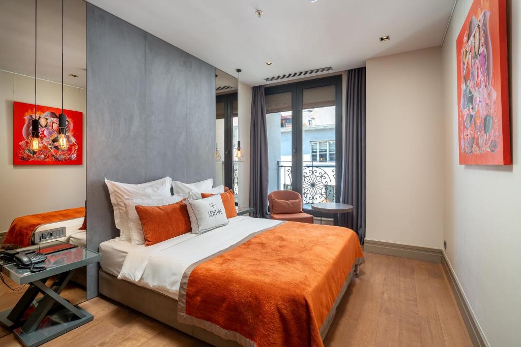 een slaapkamer met een groot bed en een oranje deken bij Sentire Hotels & Residences in Istanbul