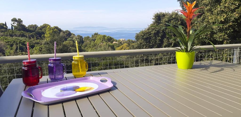 un plateau avec quatre bouteilles sur une table sur un balcon dans l'établissement L'escapade, à Rayol-Canadel-sur-Mer