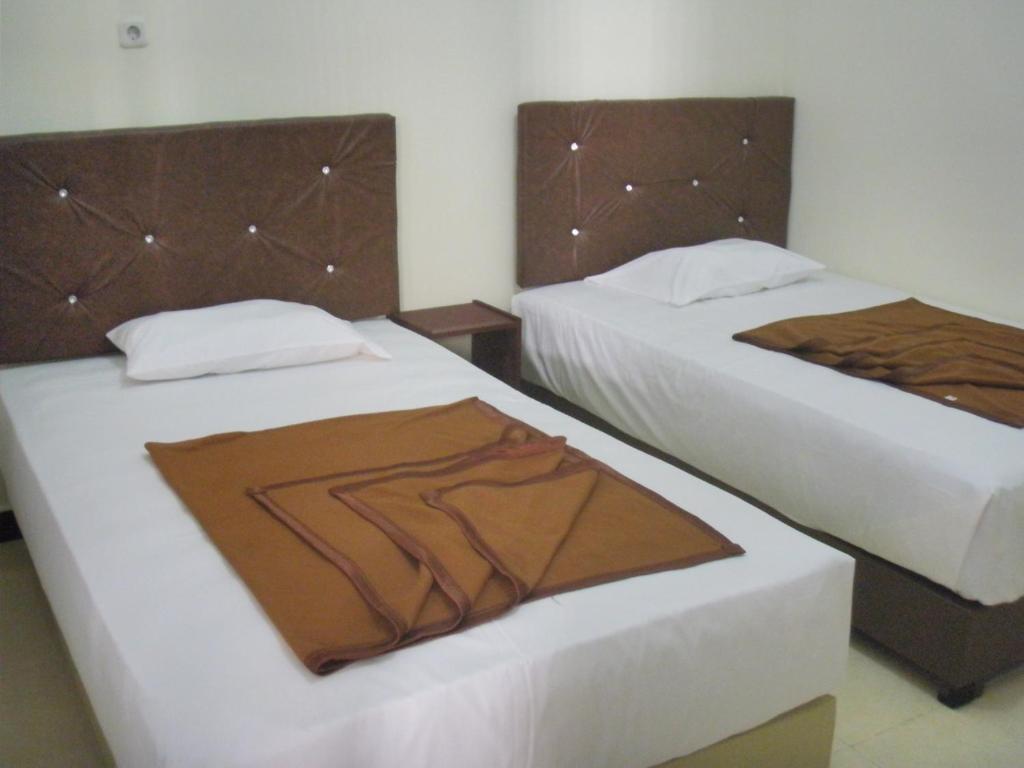 dos camas sentadas una al lado de la otra en una habitación en Dena Hotel, en Soe