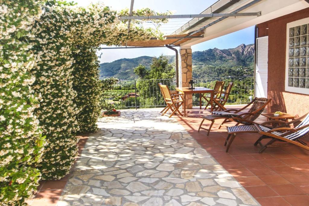 a patio with chairs and an ivy covered wall at Lo Scoglio - Goelba in Capoliveri