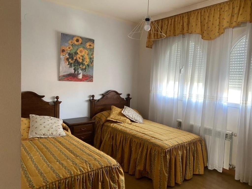 - une chambre avec 2 lits et une fenêtre dans l'établissement Villa Miriam, à Padul