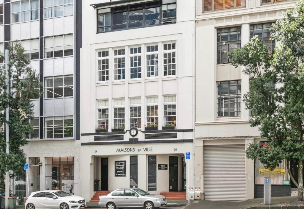 a white building with cars parked in front of it at Maison Marvel l Enormous Loft Apt l Heart of City in Auckland