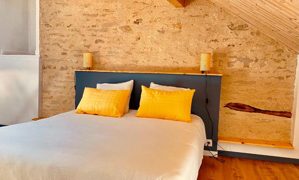 a bedroom with a bed with two yellow pillows at La Chambre du Clos - Meursault in Meursault