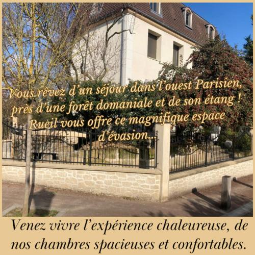 un panneau sur une clôture devant une maison dans l'établissement Séjour à la Châtaigneraie, à Rueil-Malmaison