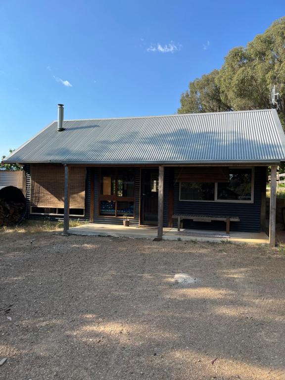 a building with a bench in front of it at Rainbow Valley Bunkhouse in Marraweeney
