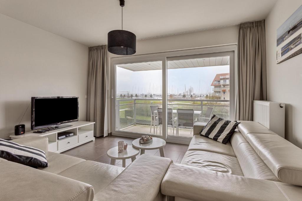 a living room with a couch and a large window at Villa Emilia 0206 P104 in Nieuwpoort