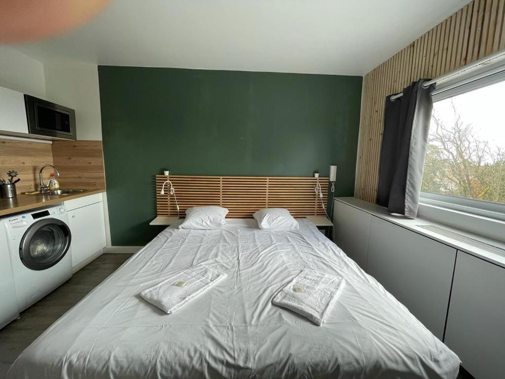1 dormitorio con 1 cama con 2 toallas en Appartement design tout confort (parking gratuit), en Gradignan