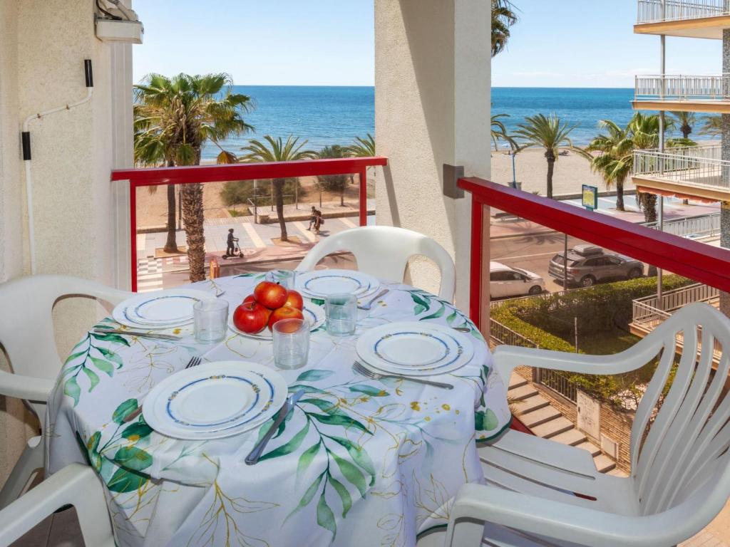 a table with plates of food on a balcony with the beach at Apartment Ancora by Interhome in Salou