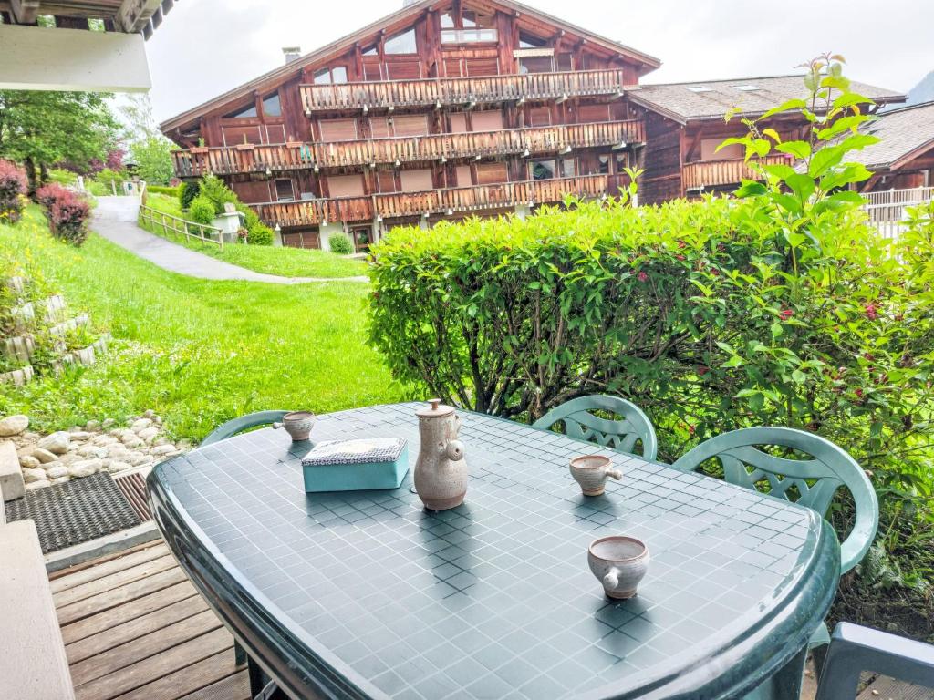 une table bleue et des chaises sur une terrasse avec un bâtiment dans l'établissement Apartment Les G'rets-4 by Interhome, à Saint-Gervais-les-Bains