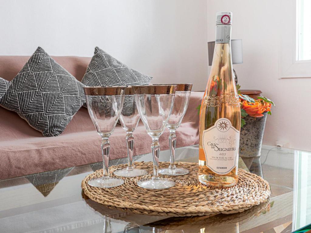 a bottle of wine and three wine glasses on a table at Apartment Le Rossi by Interhome in Nice