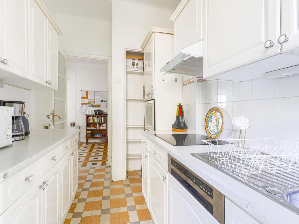 a kitchen with white cabinets and a checkered floor at Apartment Le Rossi by Interhome in Nice