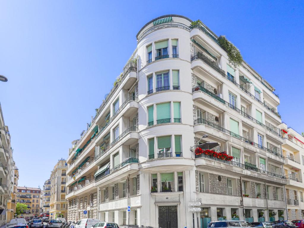 a tall white building with balconies on a street at Apartment Le Rossi by Interhome in Nice
