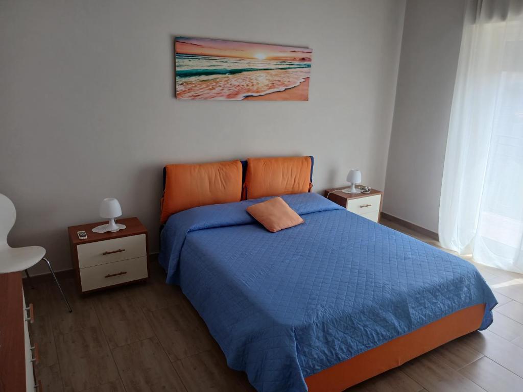 1 Schlafzimmer mit einem blauen Bett und einem orangefarbenen Kopfteil in der Unterkunft CasaLory in Catania