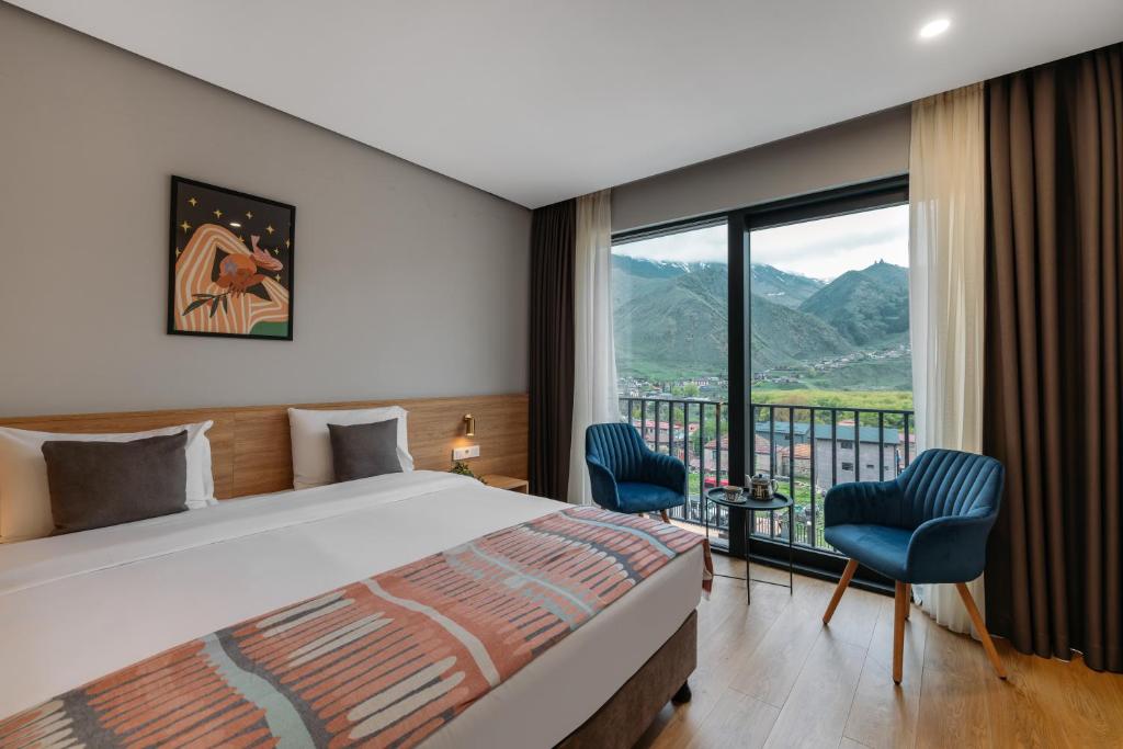 sypialnia z łóżkiem i dużym oknem w obiekcie Hotel Memoir Kazbegi by DNT Group w mieście Stepancminda