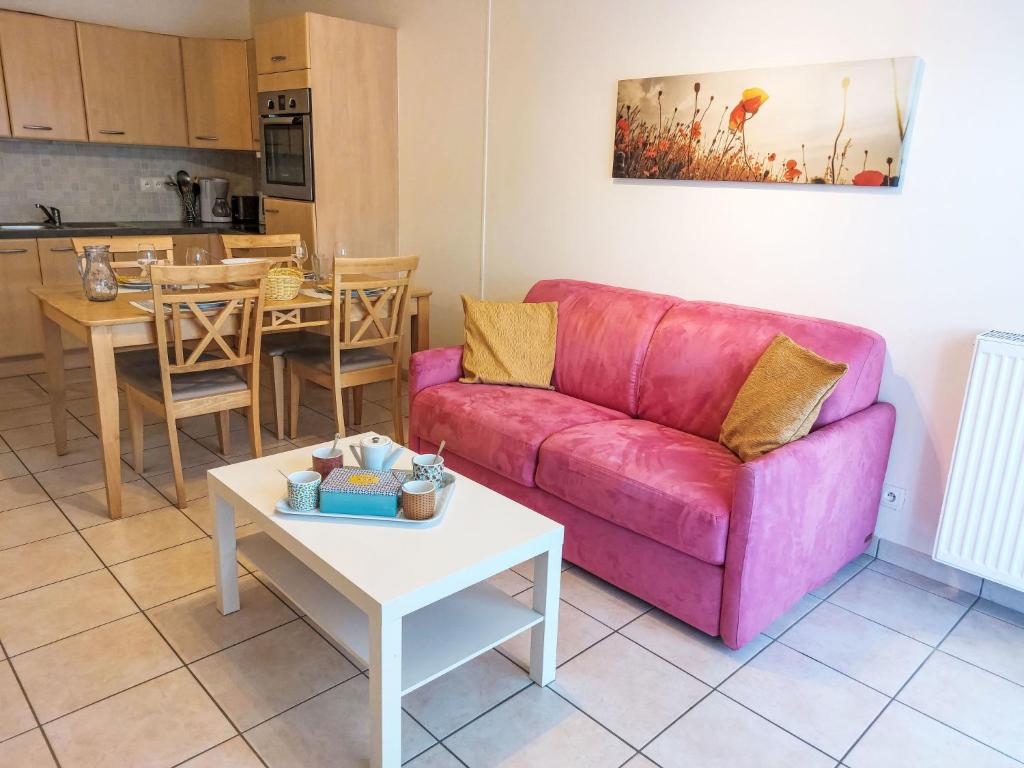 a living room with a pink couch and a table at Apartment Domaine de Crespin-3 by Interhome in Saint-Gervais-les-Bains