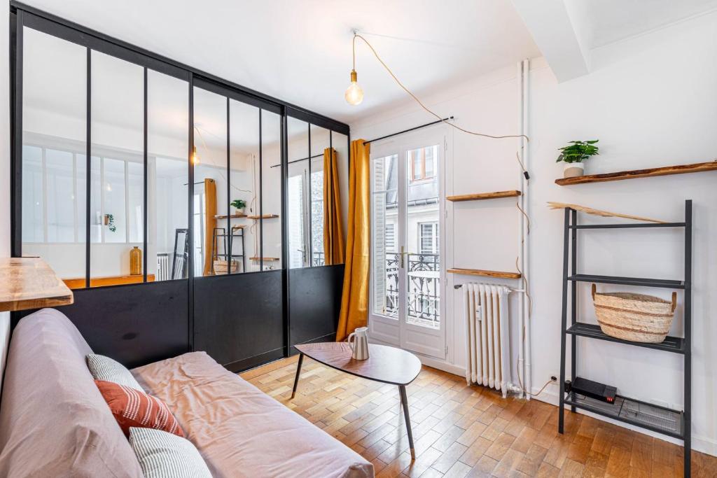 un salon avec un canapé et une table dans l'établissement GuestReady - Bel Apt. dans le 17ème, à Paris